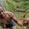 Un homme tenant un crabe devant un Salto La Jalda (Randonnée et Natation).